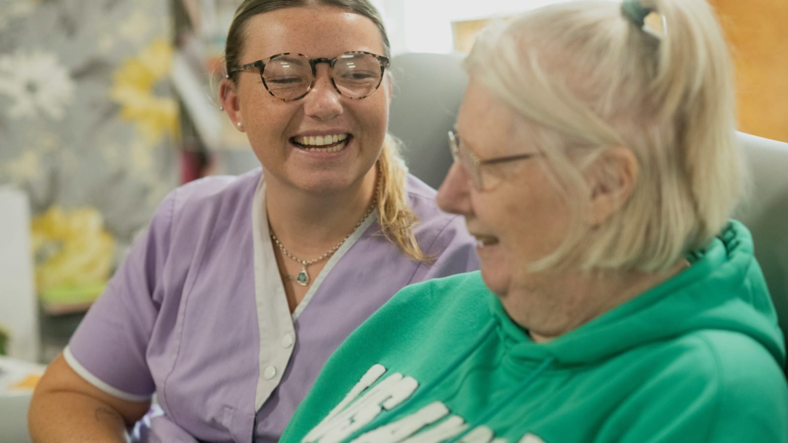 A caregiver smiling warmly with her client